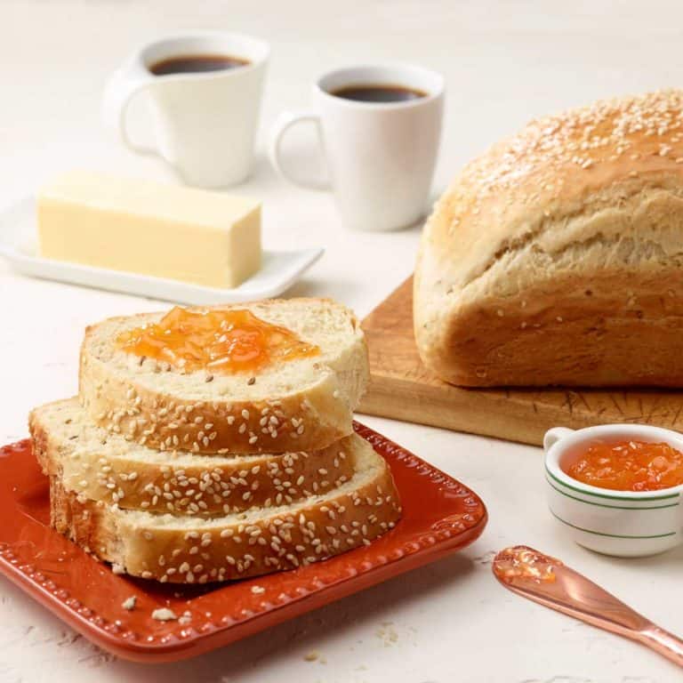 three slices of Anise Bread on a red square plate; full loaf to the right