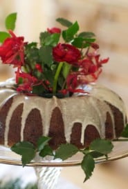 Bundt Apple Cake on a glass cake stand with flowers