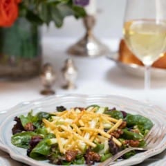 Individual plate filled with Apple and Mixed Green Salad with Apple-Truffle Vinaigrette