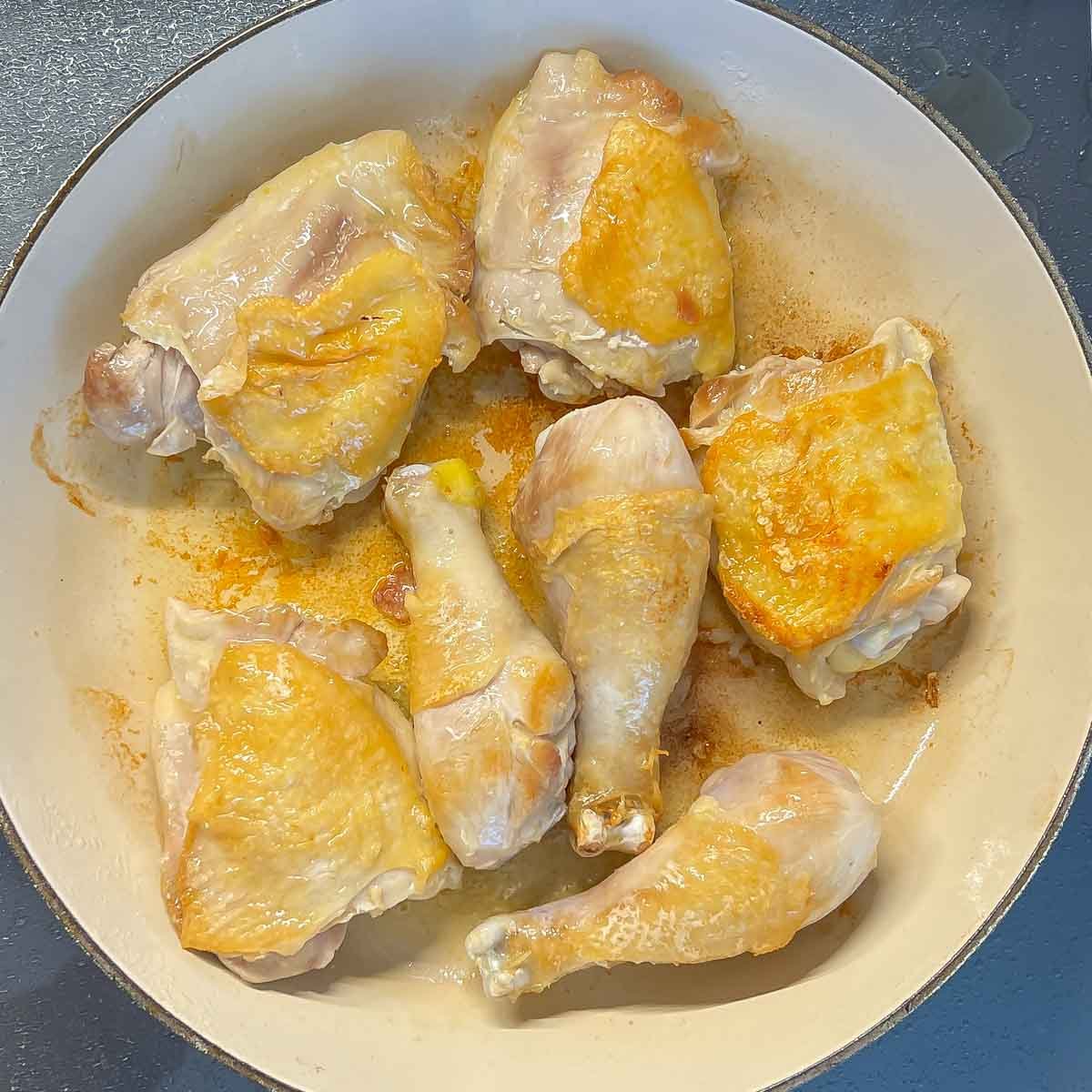 browning chicken pieces in oil in baking dish