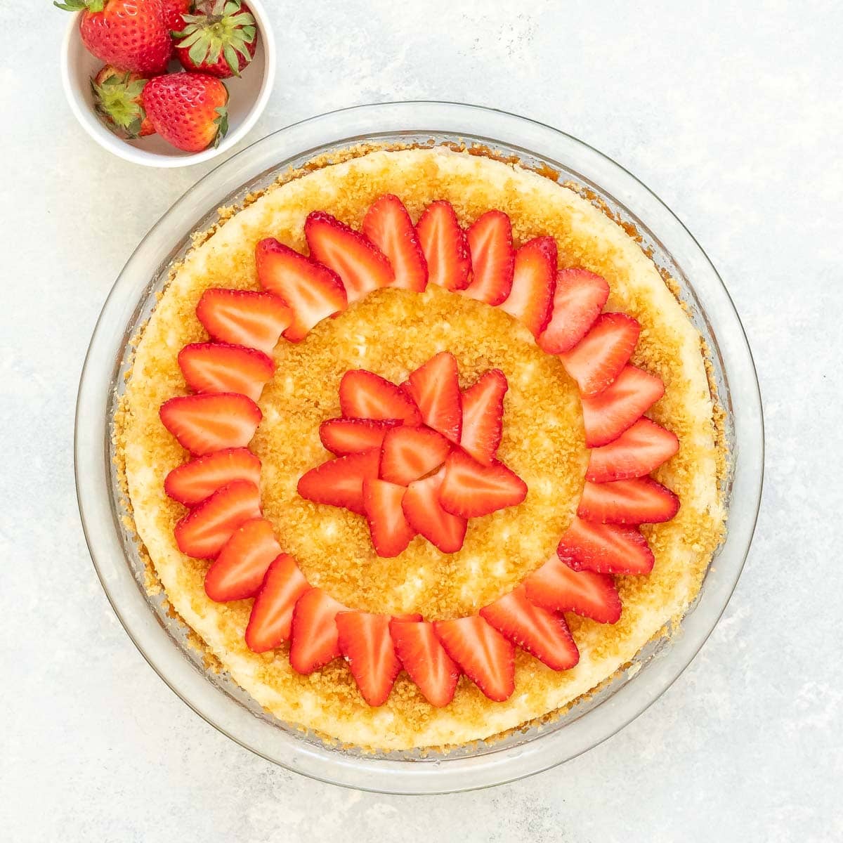 Overhead view of Cheesecake with Sour Cream Topping, with slices strawberries on top