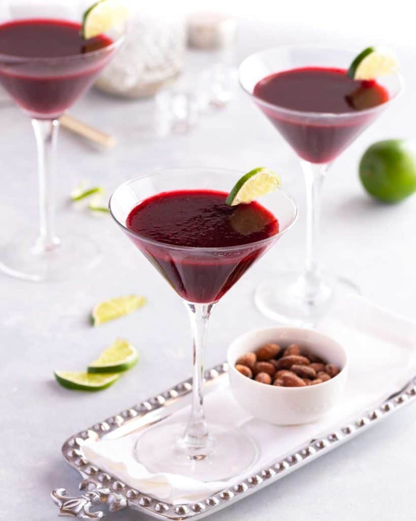 3 stemmed glasses showing Lime Blackberry Martinis