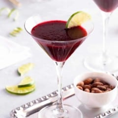 close up of a stemmed glass holding a Lime Blackberry Martini