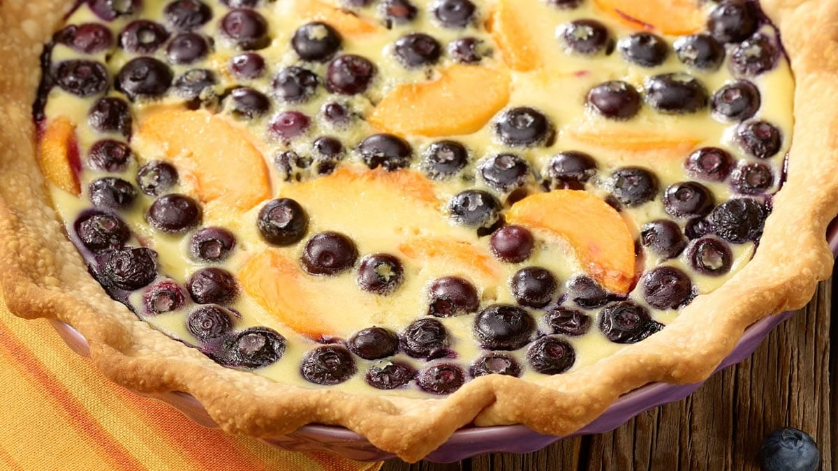 close up view of peach and blueberry custard pie