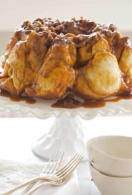 White cake stand holding Overnight Bundt Caramel Rolls