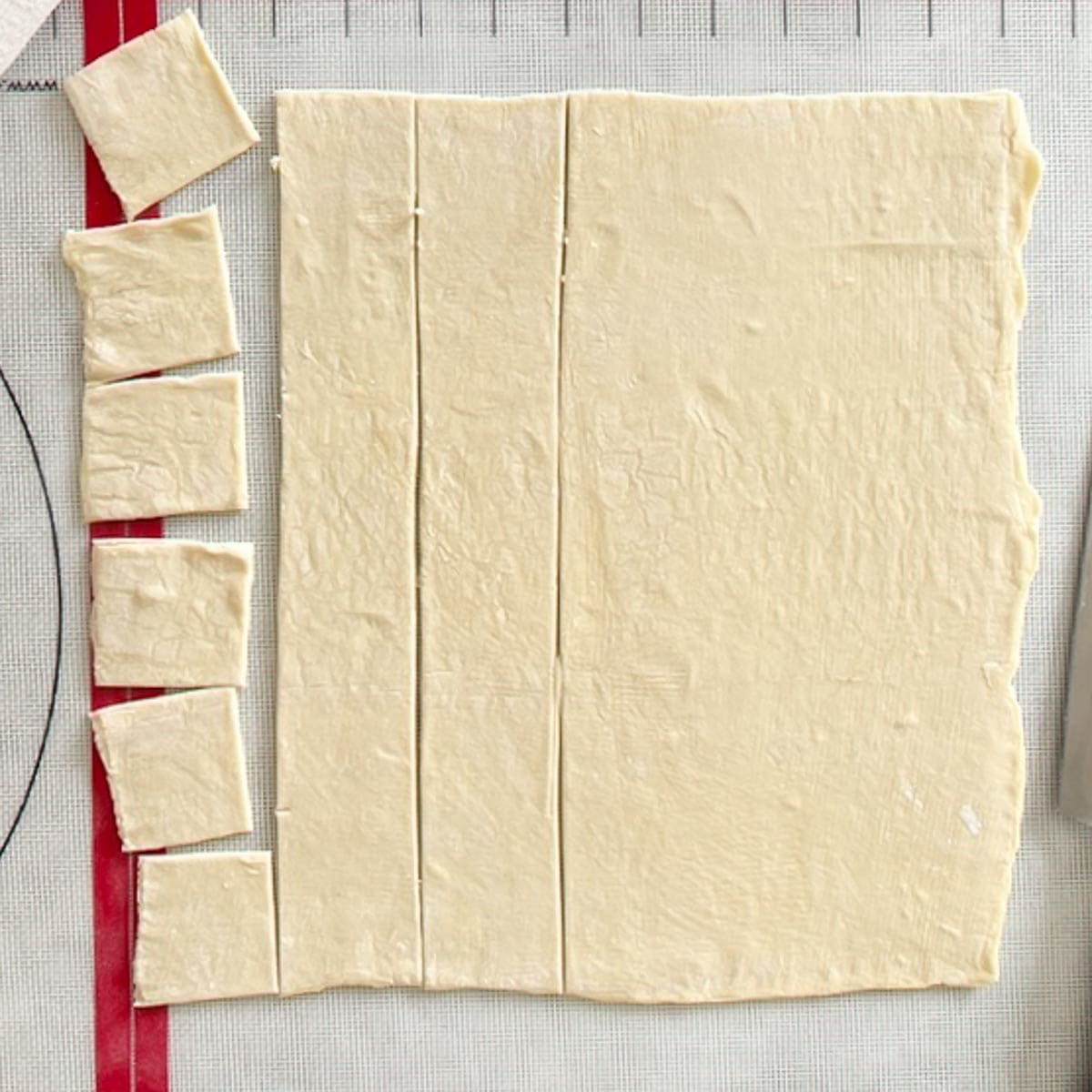Rolled puff pastry sheet with 6 squares cut out