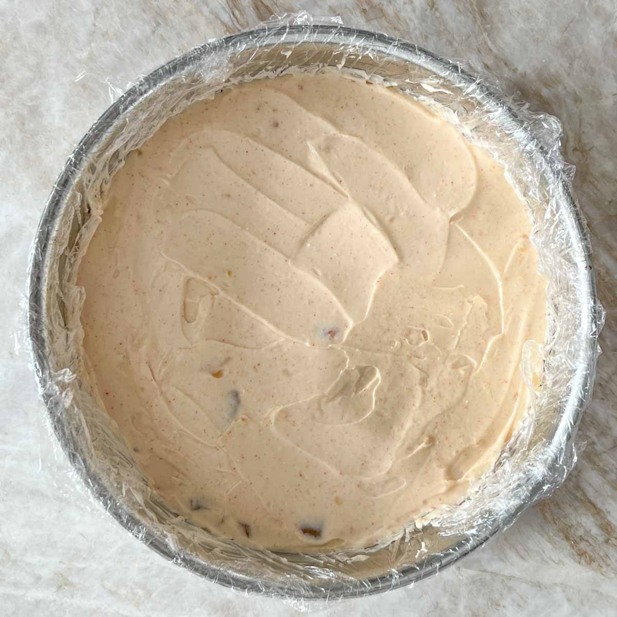 spring form pan with second layer of cream cheese and chutney mixture spread evenly in pan