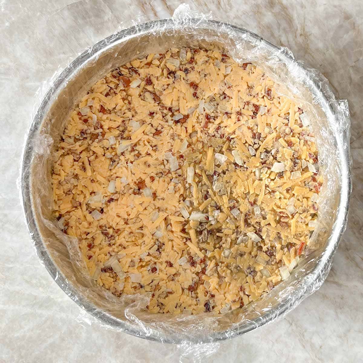 spring form pan with first layer of Chedder cheese mixture spread evenly on bottom