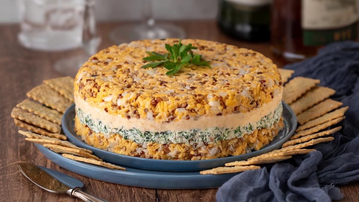 Close up of cheddar Cheese Torte on a blue plate surrounded by crackers