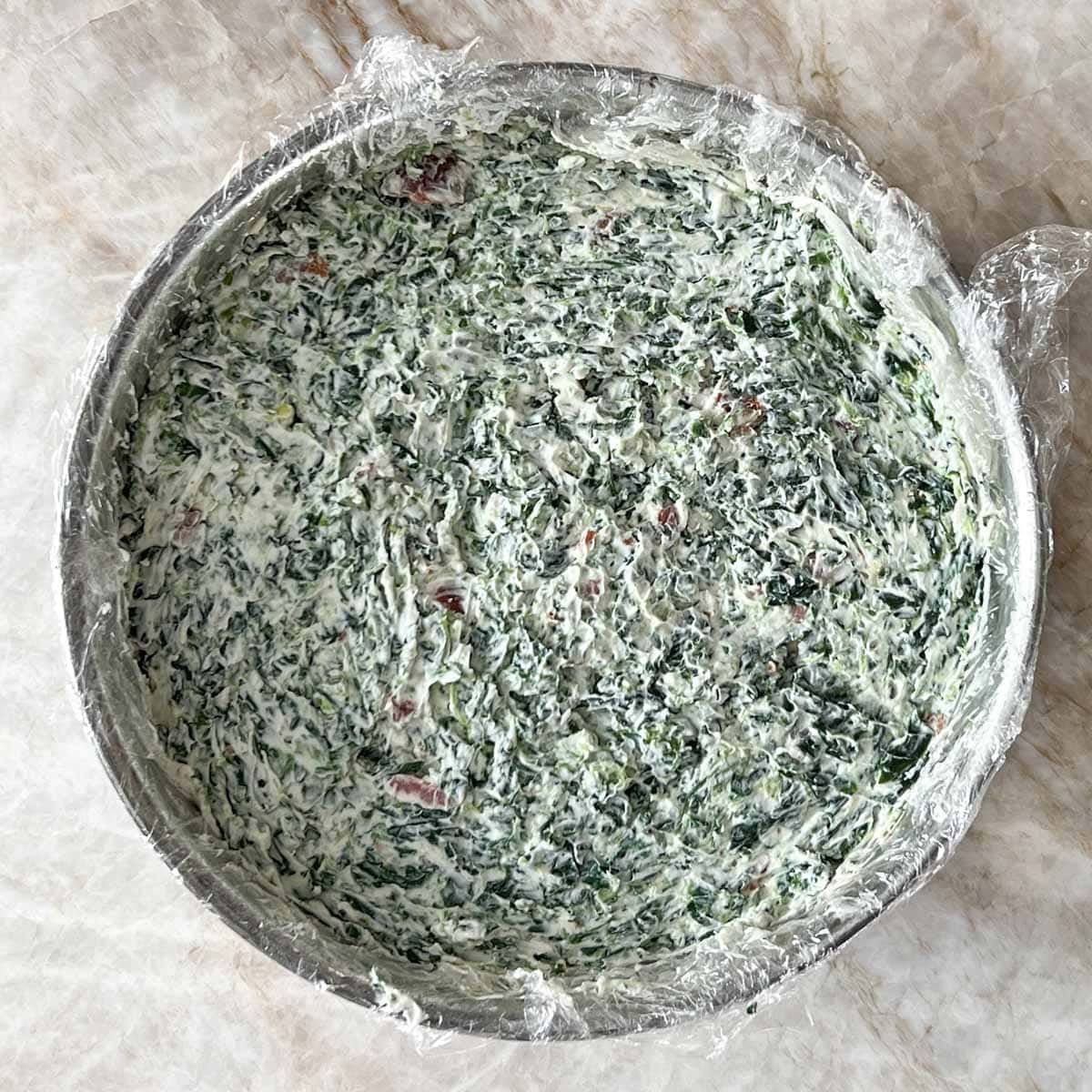 Spring form pan with cream cheese, spinach and bacon layer added