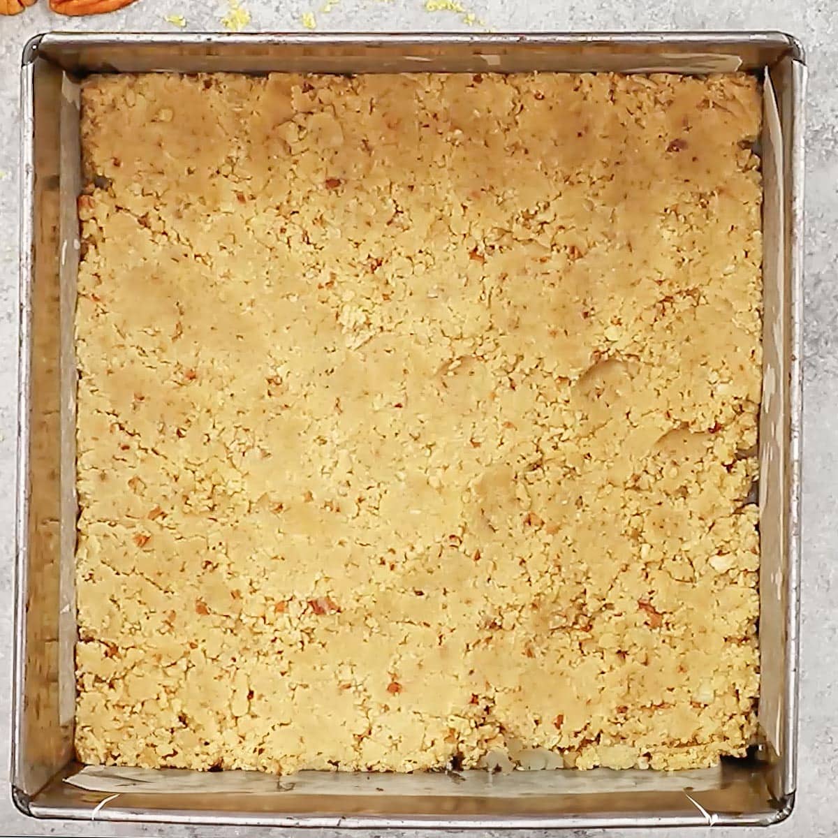 process shot showing the crust pressed into the bottom of an 8 by 8-inch baking dish