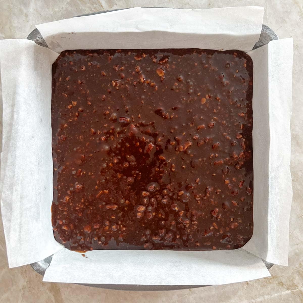 Uncooked brownie batter in prepared baking dish