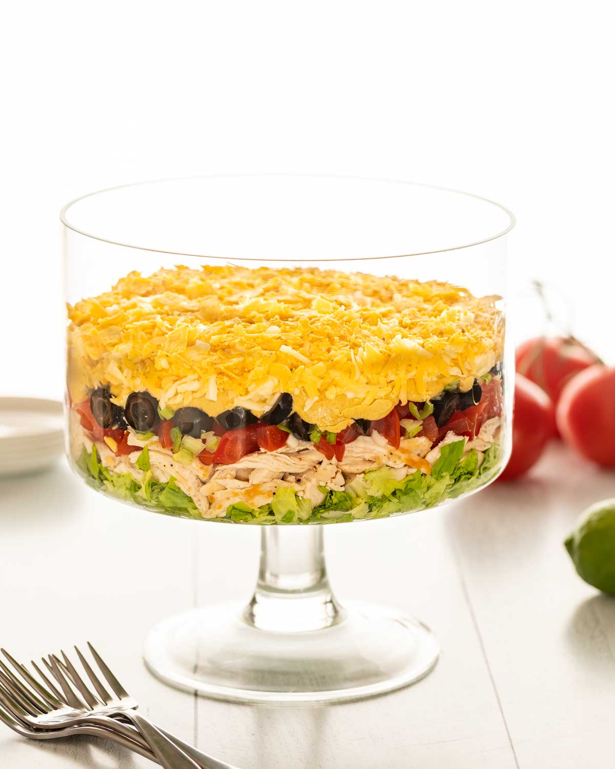 side view of a trifle dish filled with Shredded Chicken Taco Salad, with the ingredients arranged in layers
