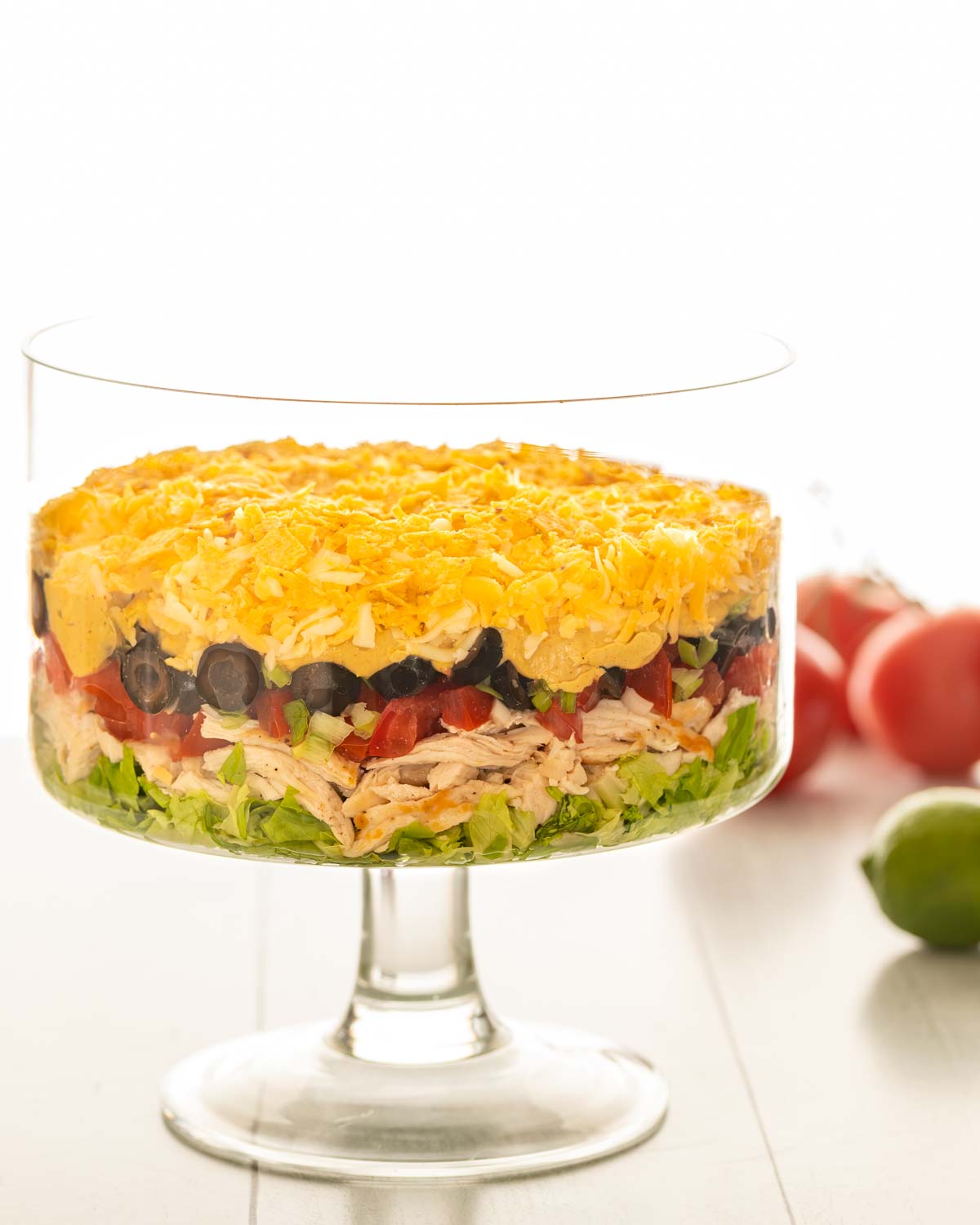 side view of a trifle dish filled with Shredded Chicken Taco Salad, with the ingredients arranged in layers