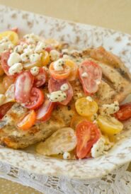Gold and white platter holding Grilled Chicken with Tomatoes and Goat Cheese