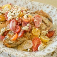 Gold and white platter holding Grilled Chicken with Tomatoes and Goat Cheese