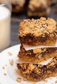 Stack of 3 Layered Oatmeal Chocolate Bars on a white plate, with a glass of milk