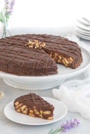 Biscuit cake on a cake stand with a slice on a plate in front