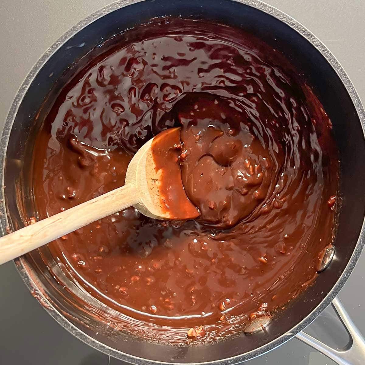 saucepan holding chocolate layer ingredients after adding pecans