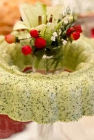 glass stand holding Cilantro Mousse ring filled with flowers