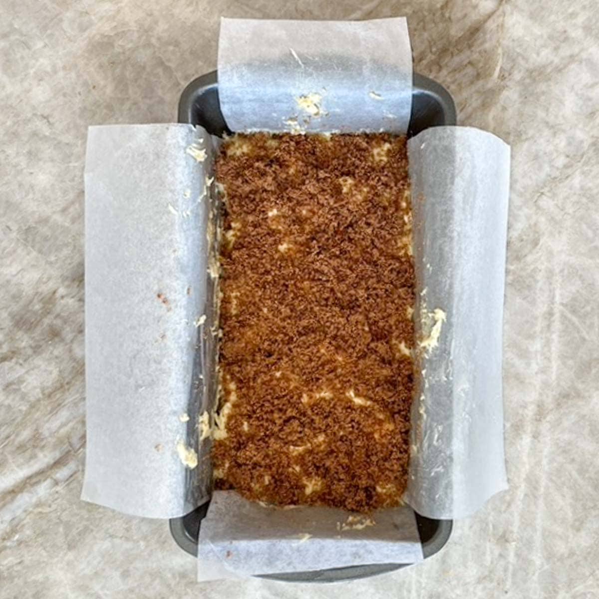 Overhead view of first layer of batter in prepared pan, with cinnamon-sugar mixture sprinkled on top