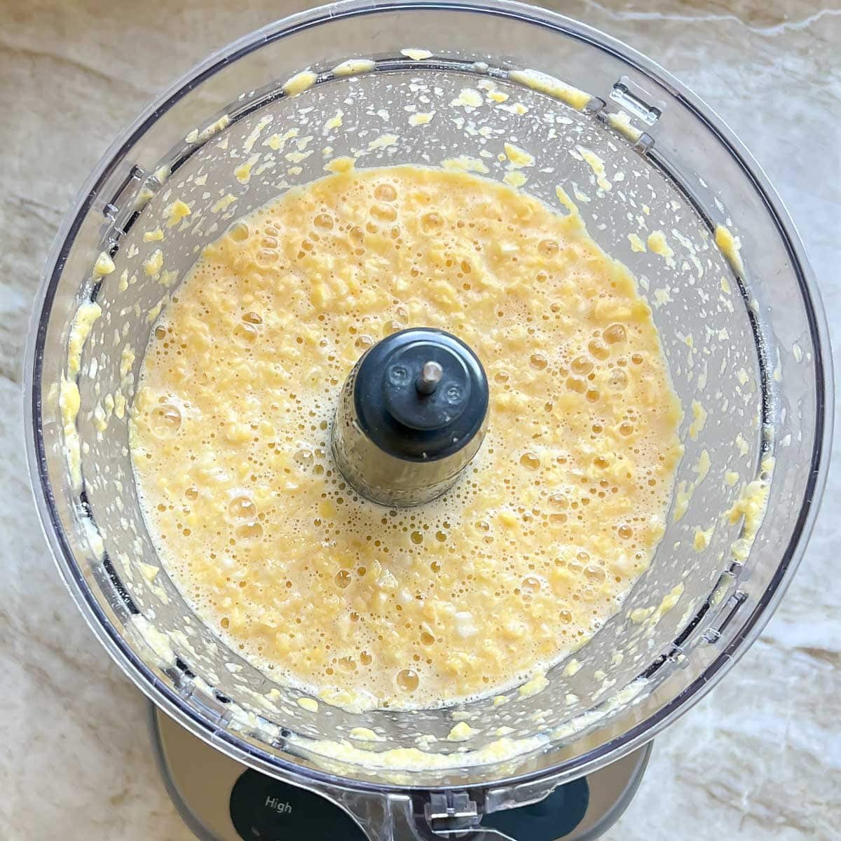 processed corn mixture in bowl of food processor