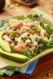 serving platter with Crab and Shrimp Salad atop mixed greens with sliced avocado alongside