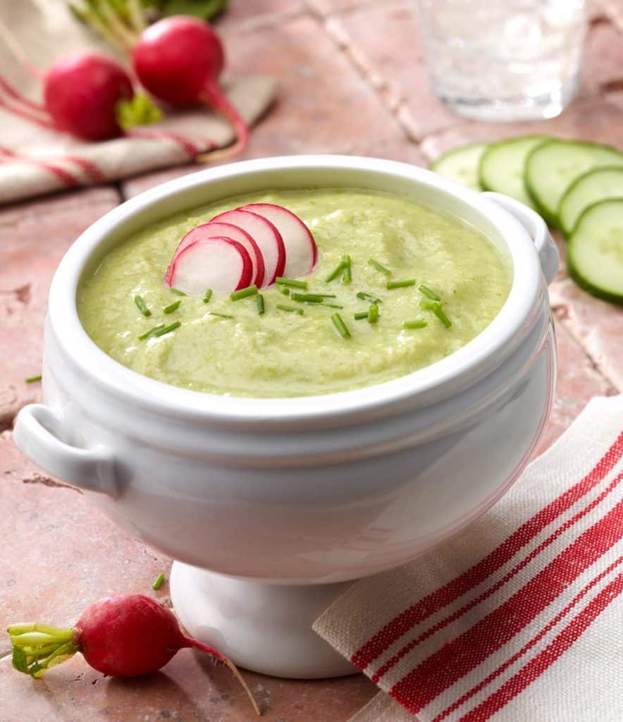 Cucumber Leek Soup in white bowl with sliced radishes on top