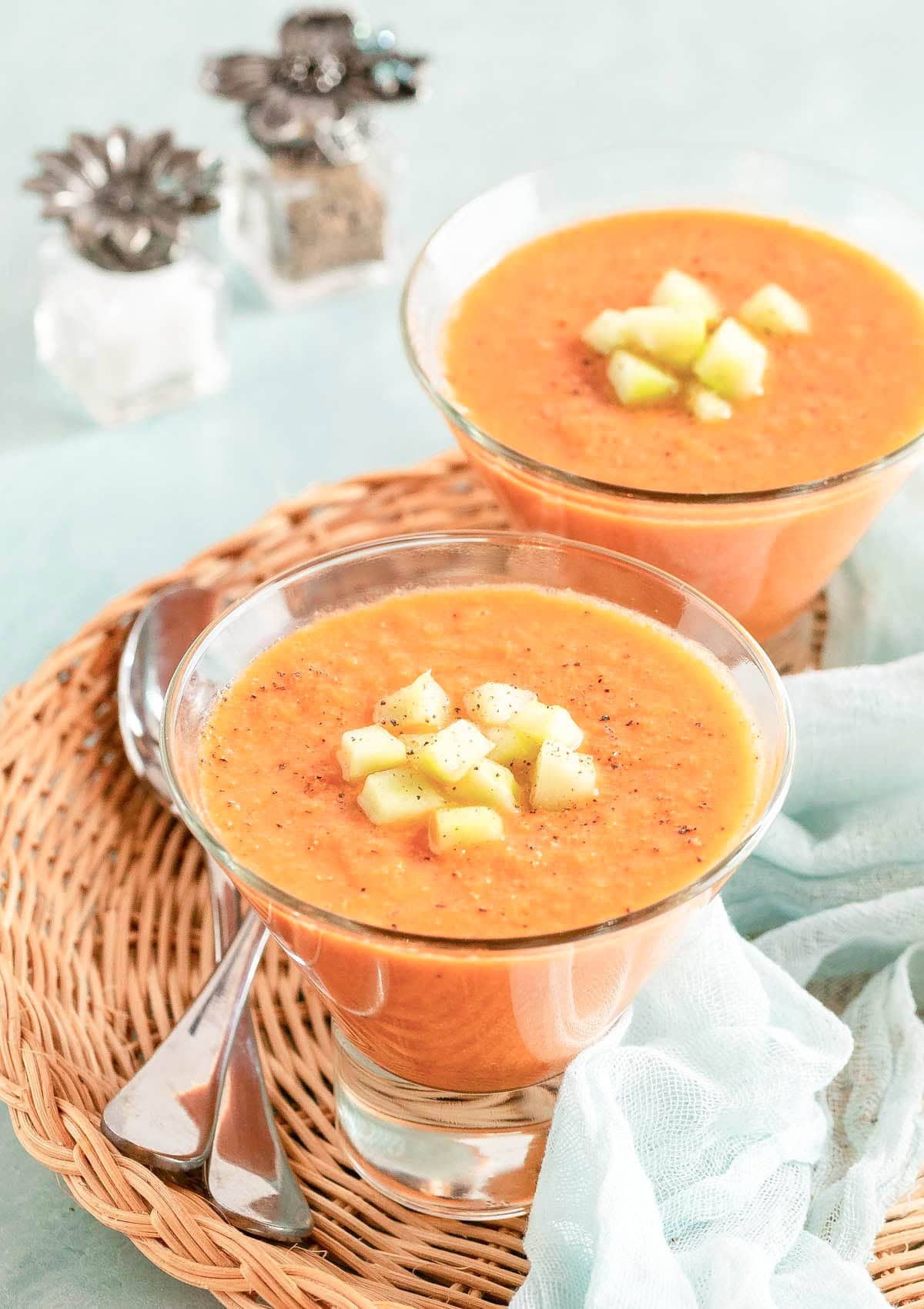 Easy Gazpacho served in two individual bowls, garnished with chopped cucumber.