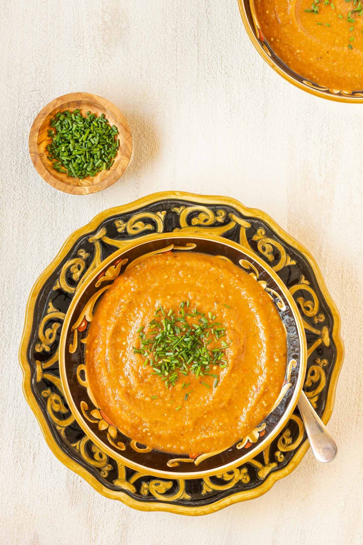 Overhead view of a bowl holding a portion of Roasted Eggplant Soup garnished with chives