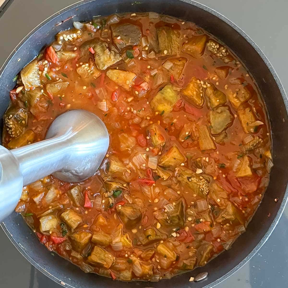 Puréeing the cooked soup with an immersion blender