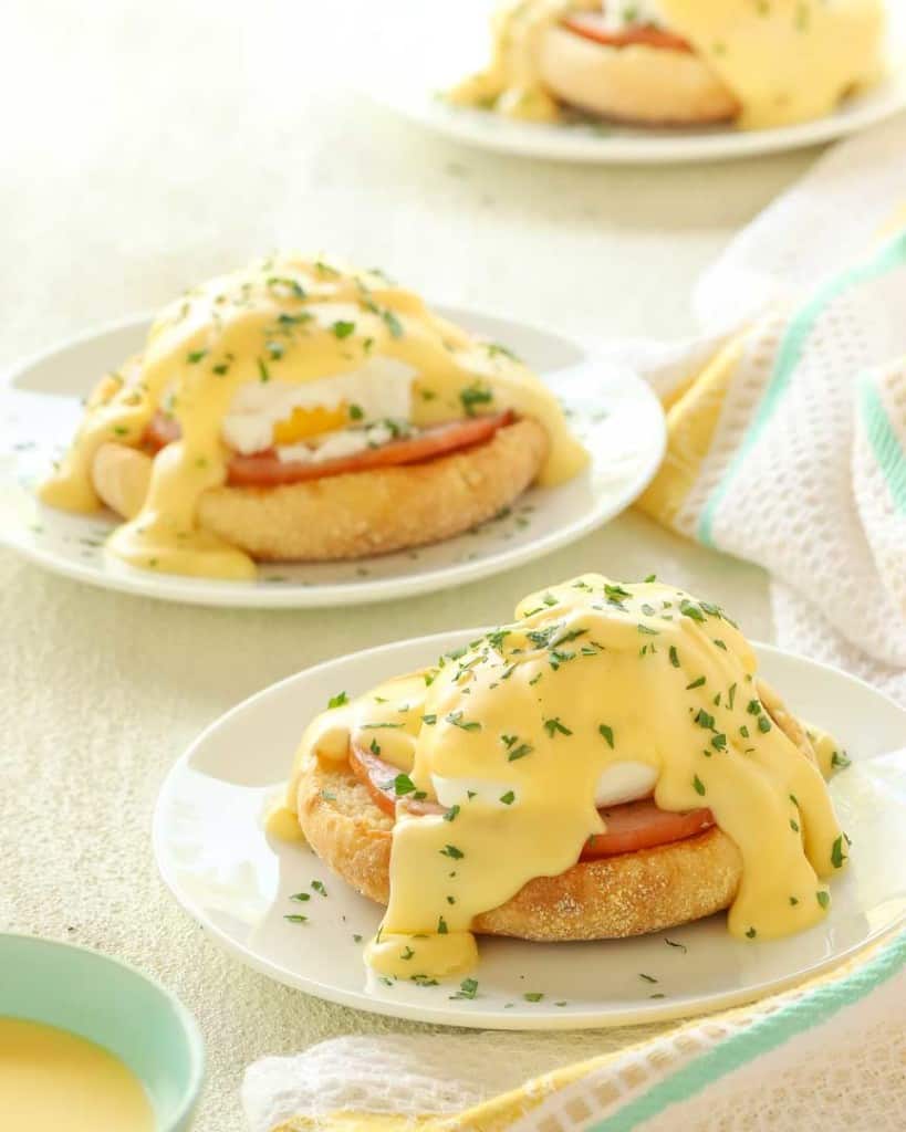 three small plates each holding one portion of Eggs Benedict
