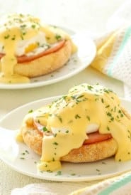 Two small plates each holding one portion of Eggs Benedict