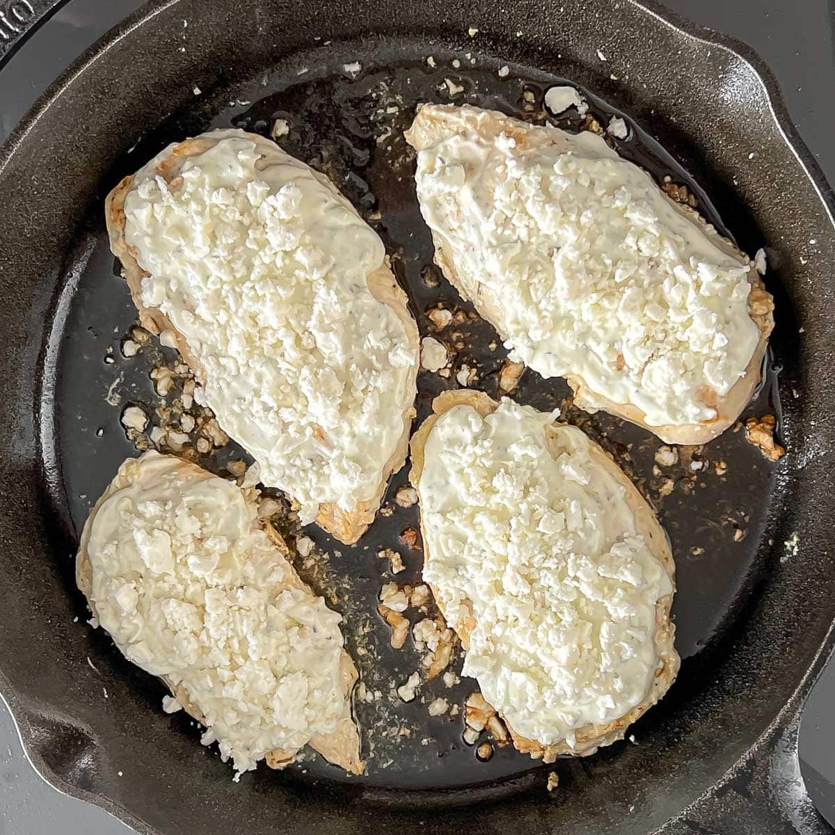 Chicken breasts in cast iron skillet, showing searing side 2