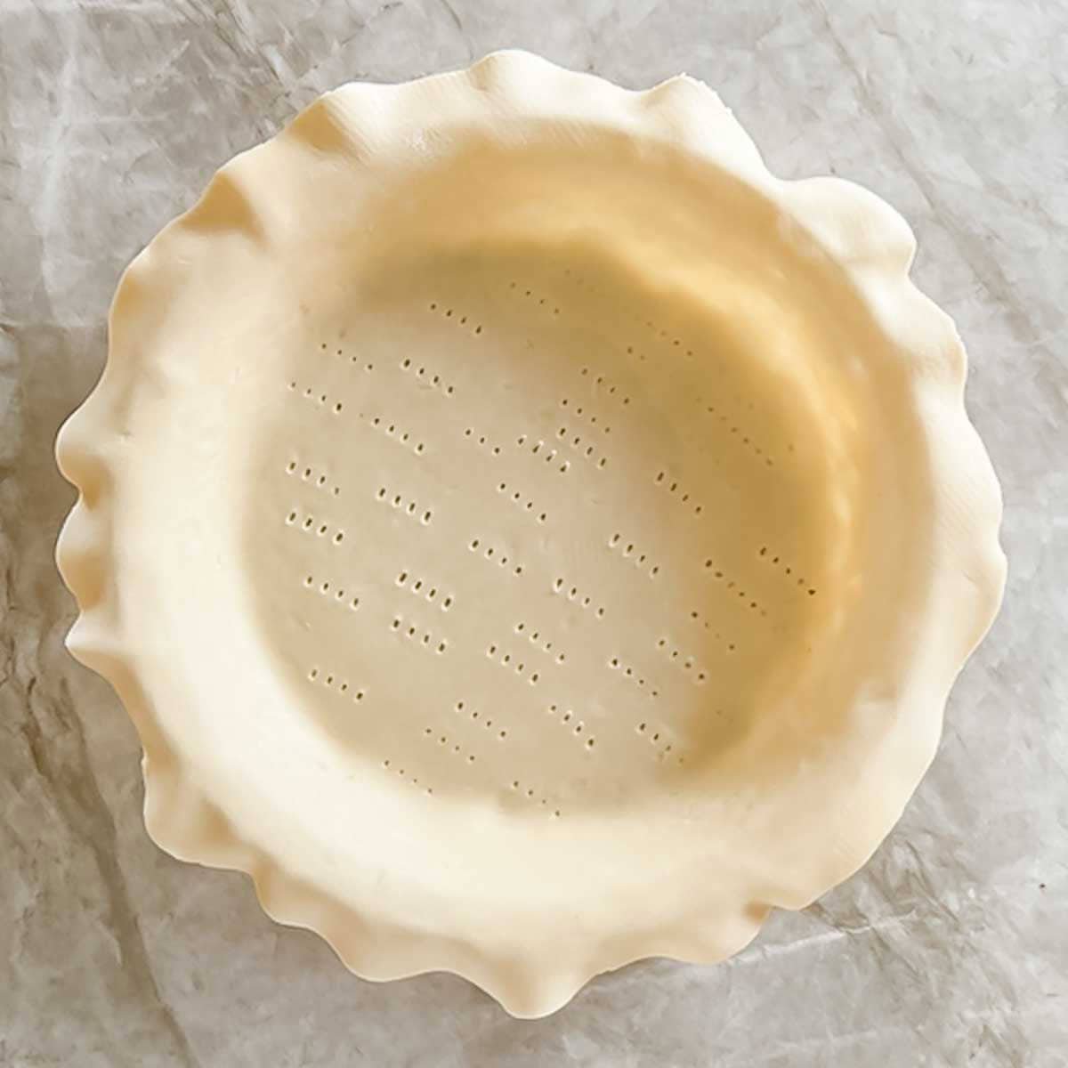 pie crust rolled and placed in pan, with edges overhanging the sides