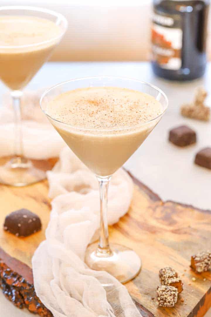 two martini glasses holding frozen brandy alexanders, with pieces of chocolate on the side
