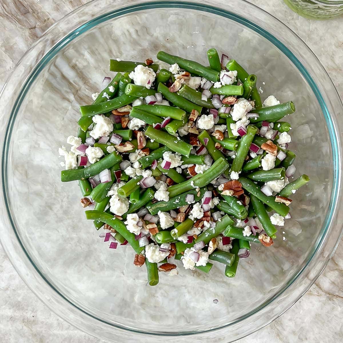 process shot of mixed salad ingredients without the dressing in a glass bowl