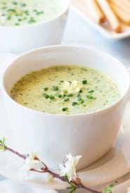 Bowl showing one serving of Pureed Green Pea Soup, with breadsticks in the background
