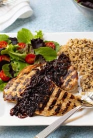 Grilled chicken breasts topped with caramelized red onion