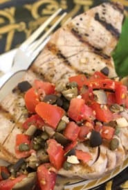 black and gold plate with Grilled Tuna with Puttanesca Sauce