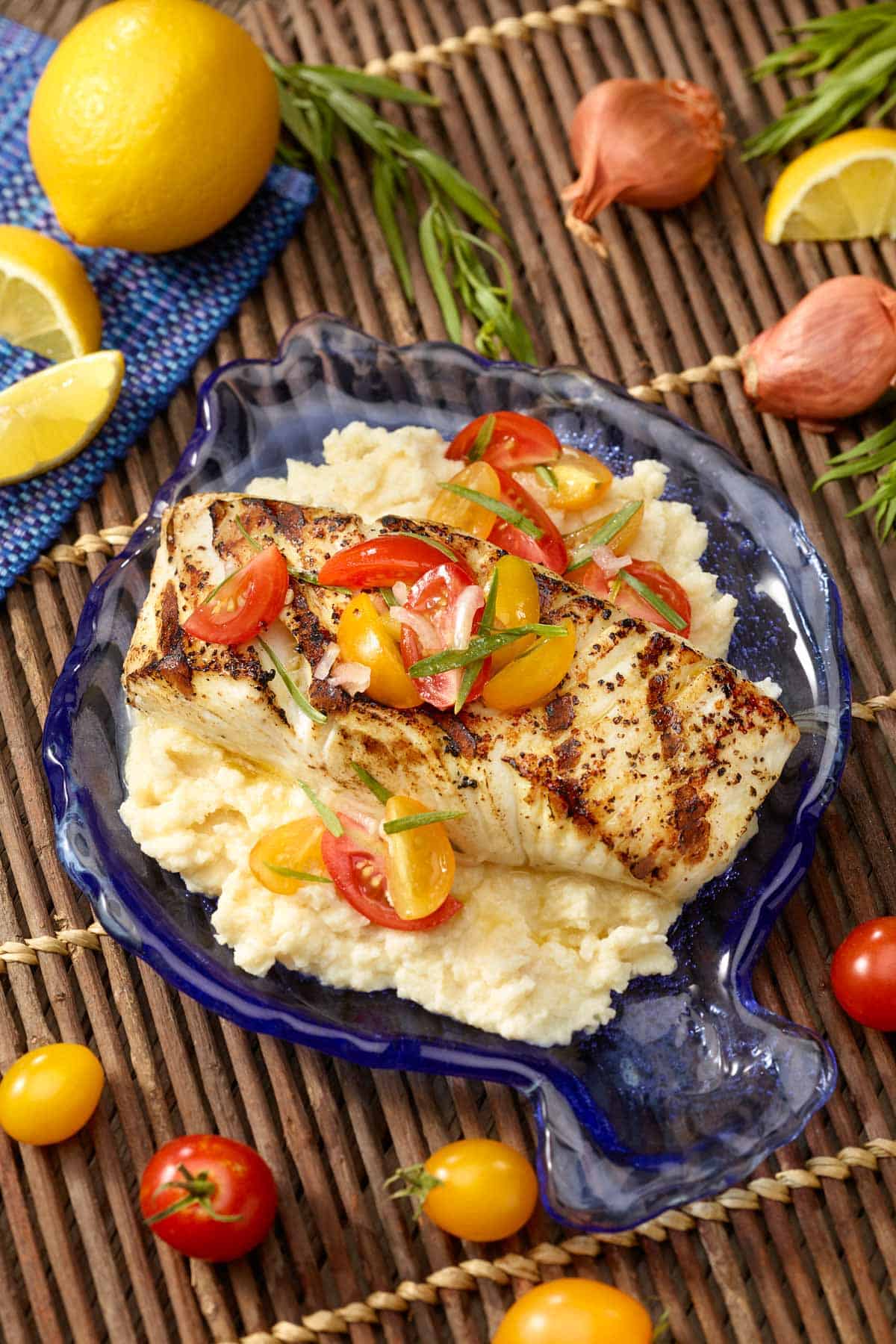 Fish shaped blue platter with Halibut with Celery Root Purée and Tomato Garnish.
