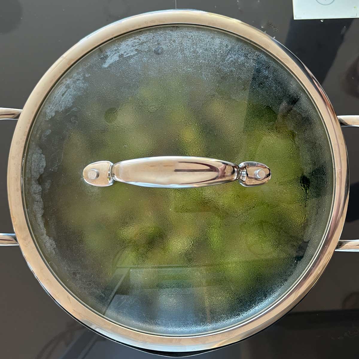 Broccoli soup ingredients in large pot on stovetop, covered