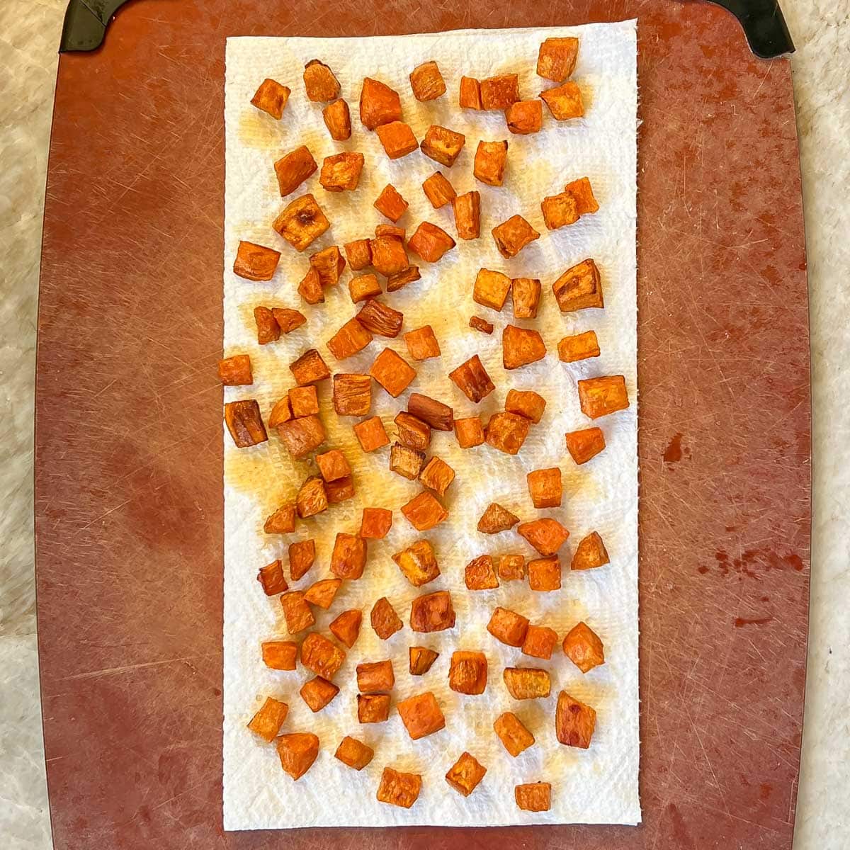 Roasted sweet potato croutons resting on paper towel to crisp up