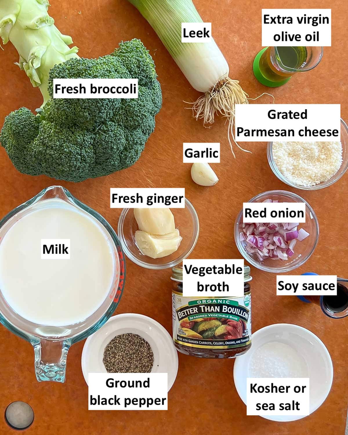 Cutting board holding ingredients in Healthy Broccoli Soup, each one labeled