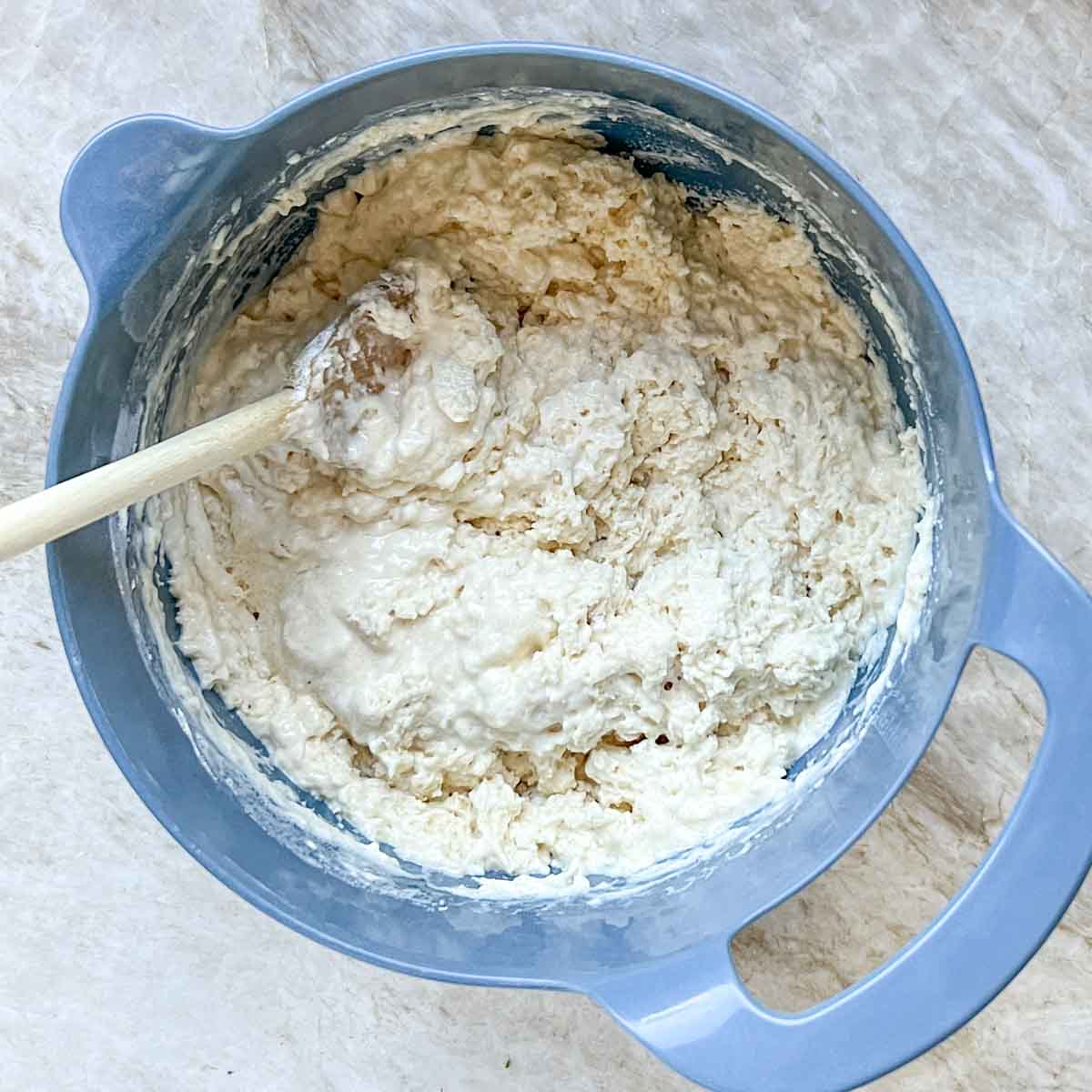 Overhead view of drop biscuit dough in a blue bowl