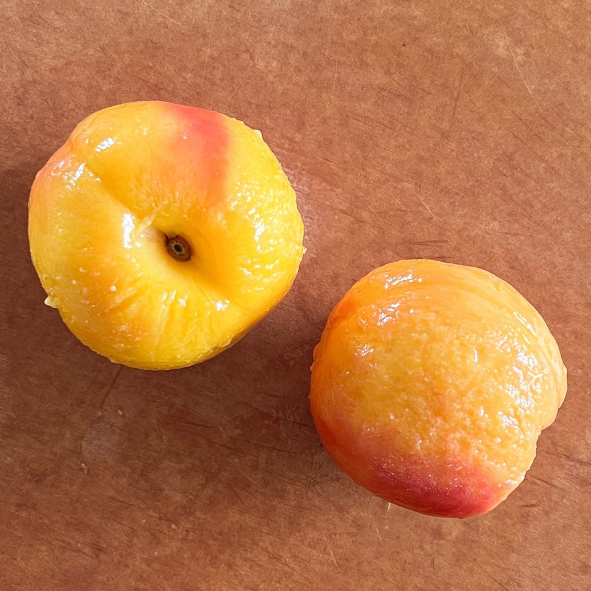 Freshly peeled peaches, ready to be sliced and pitted for use in your favorite recipes.