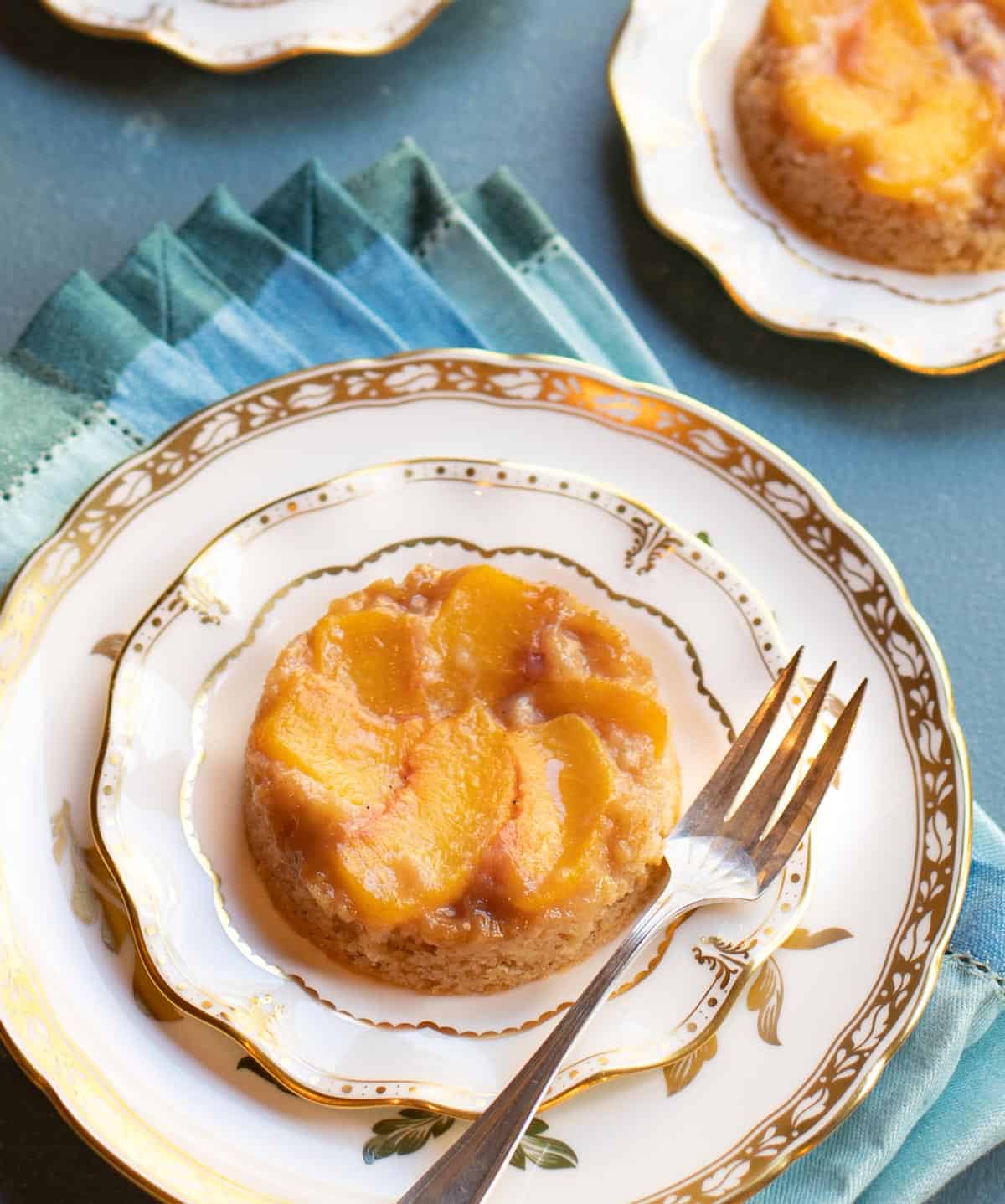 Individual upside down peach cake on dessert plate with fork