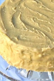 glass cake sand holding Jam Cake with Caramel Frosting