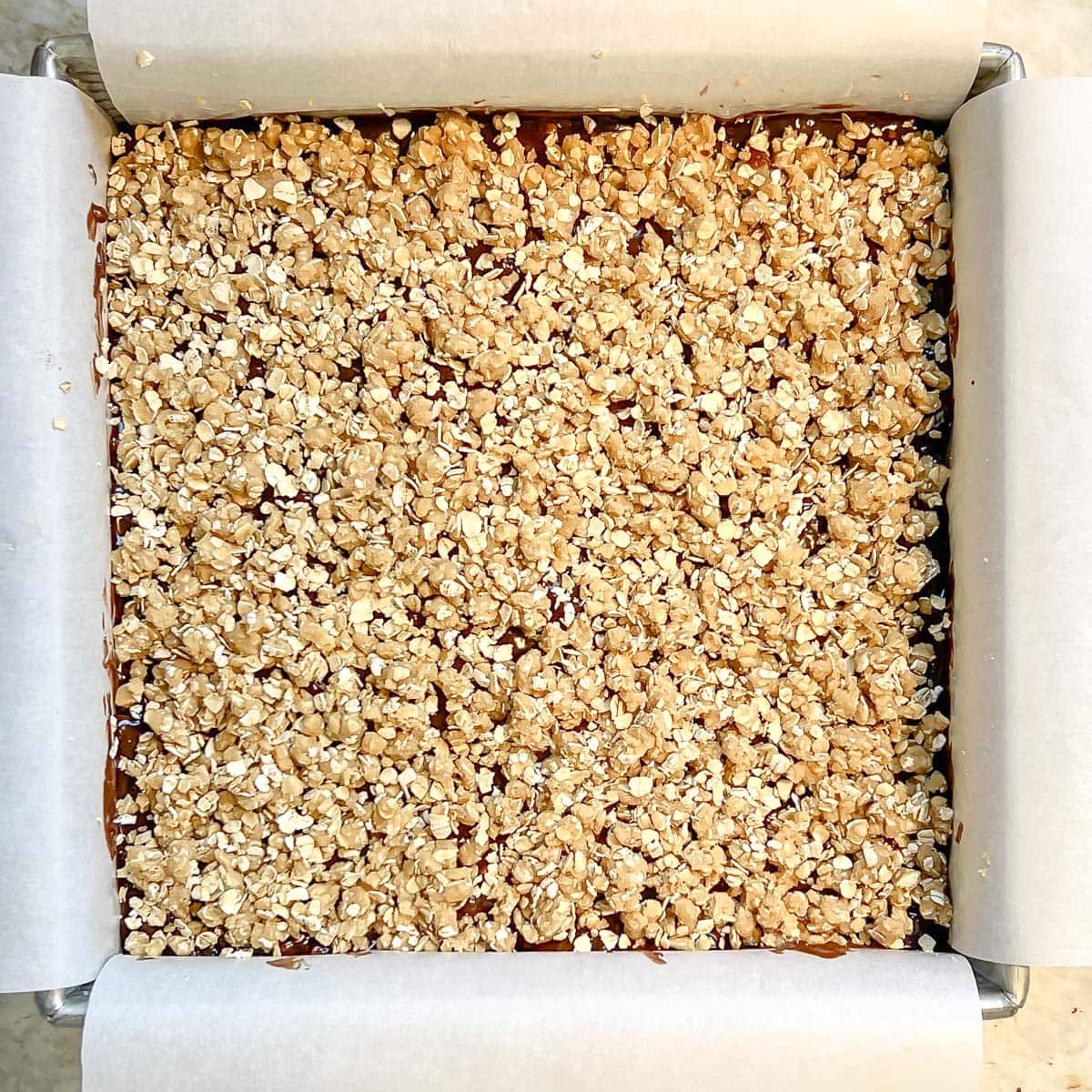 top layer of crumbled oat cookie dough on top of chocolate layer