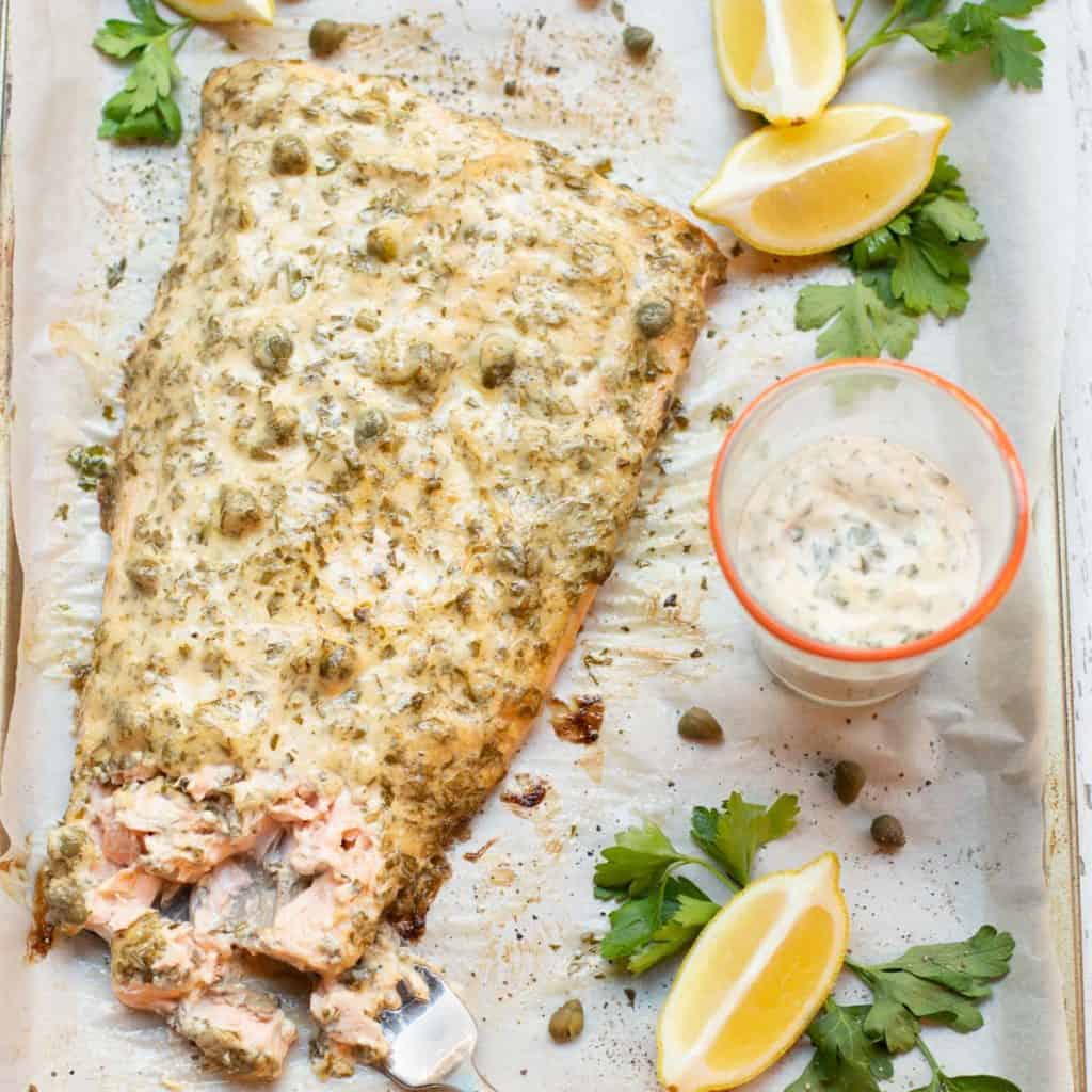 Salmon filet with lemon caper sauce on top and on the side
